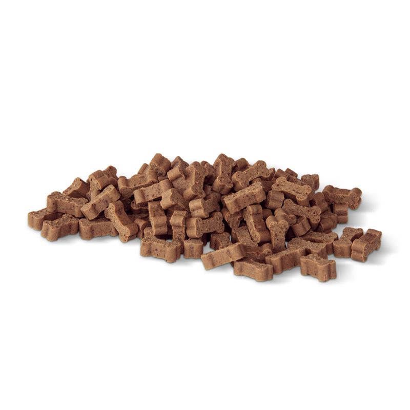 Pile of brown dog treats shaped like bones on a white background