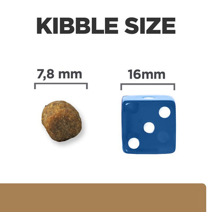 Kibble size comparison with a piece of kibble and a blue die showing measurements.